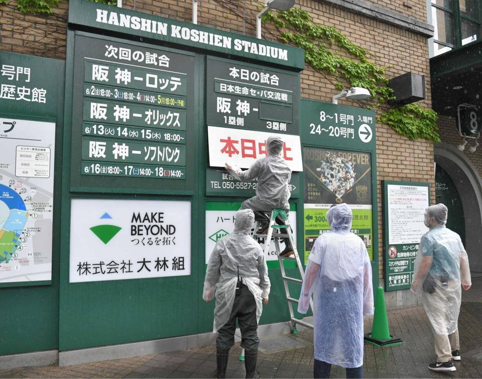 　本日中止の看板を準備する球場関係者