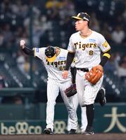 　延長１２回、中村奨を投ゴロに打ち取り、拳を握る湯浅（左）＝撮影・中田匡峻