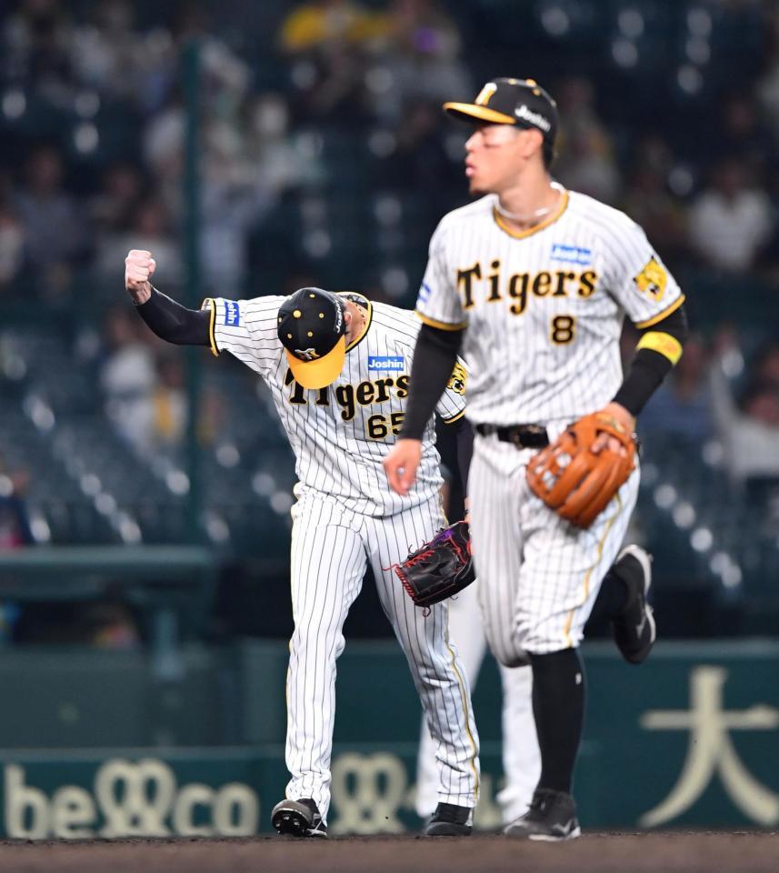 　延長１２回、中村奨を投ゴロに打ち取り、拳を握る湯浅（左）＝撮影・中田匡峻