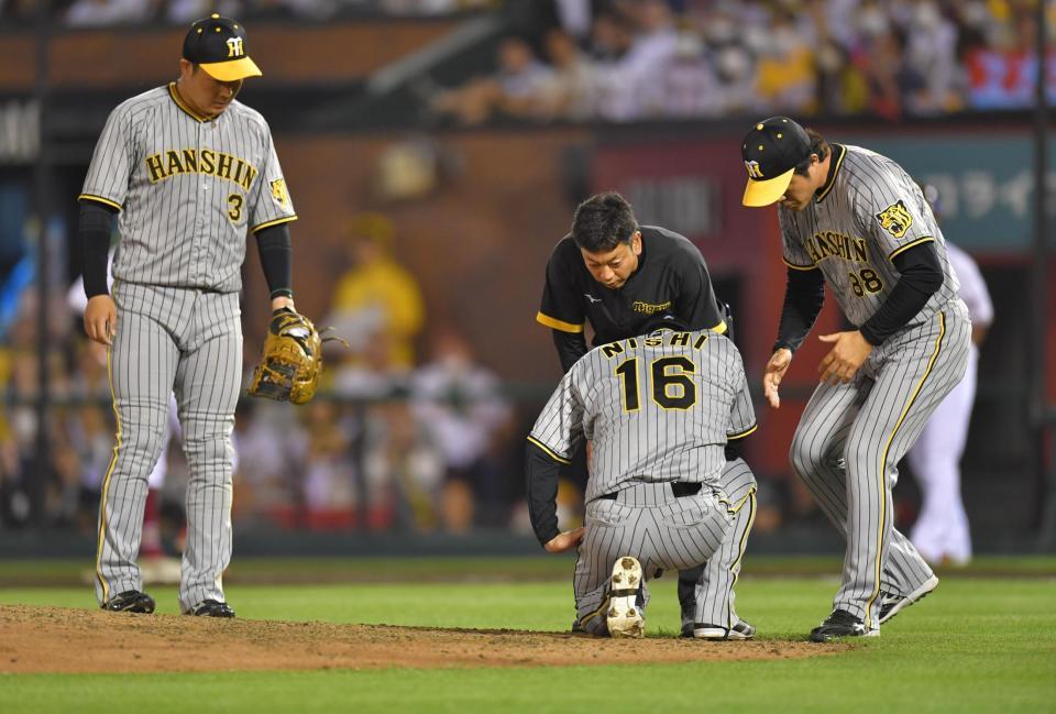 　６回、バランスを崩し、倒れ込む西勇（中央）＝撮影・西岡正