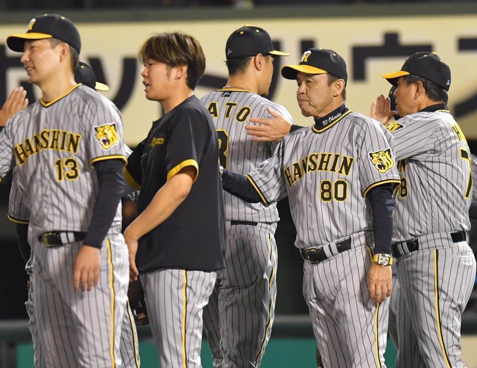 　西勇（中央左）と並んでナインを迎える岡田監督（同右）＝撮影・西岡正