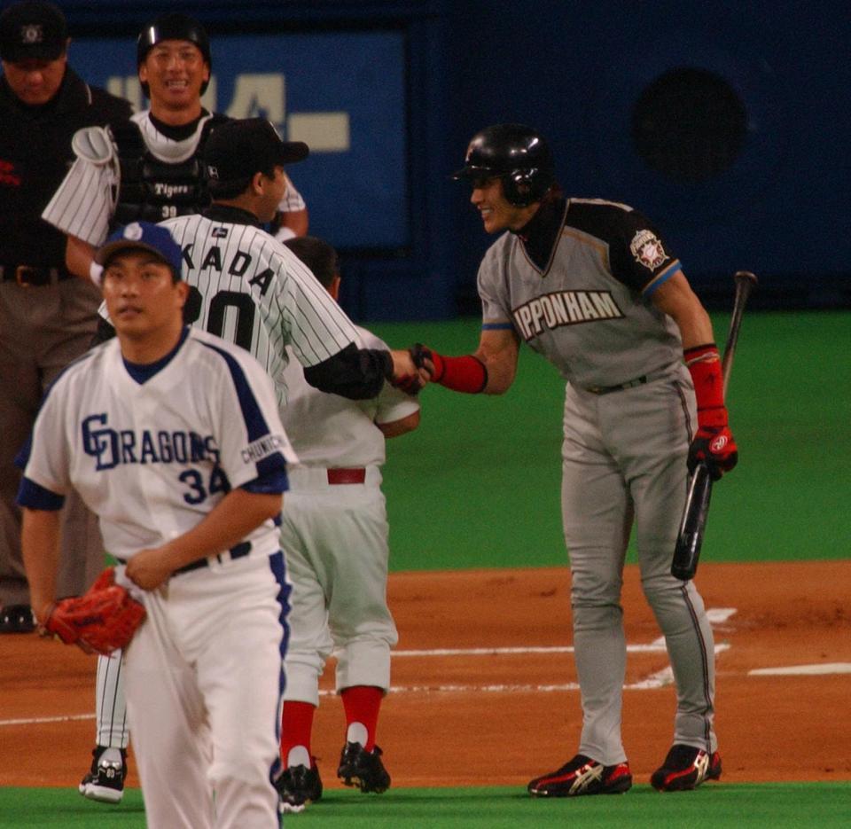 　オールスターでセ・リーグ・岡田監督（中央左）と握手を交わす日本ハム・新庄（右）＝２００４年７月