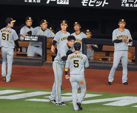 　５回、アルカンタラの中飛を好捕した近本（５）を笑顔で迎える才木（撮影・吉澤敬太）