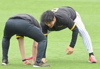 　試合前、関係者と相撲を取る佐藤輝（右）＝撮影・高部洋祐