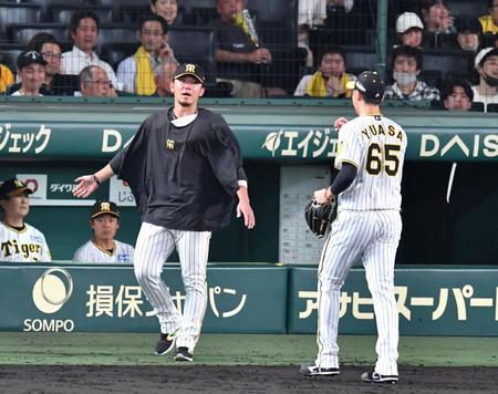 　２被弾した湯浅（右）を迎える伊藤将＝１５日