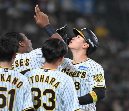 　６回、２ランを放ち、ミエセス（左奥）と共にポーズを決める佐藤輝（撮影・高部洋祐）