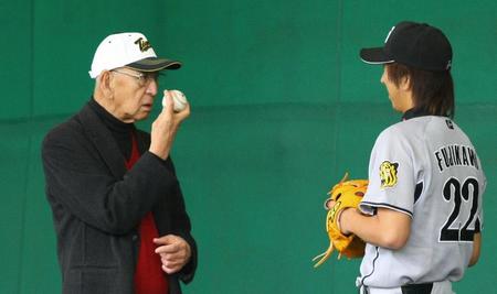 　“伝家の宝刀”フォークボールの握りを藤川（右）に伝授する杉下茂さん＝２００８年２月７日、宜野座