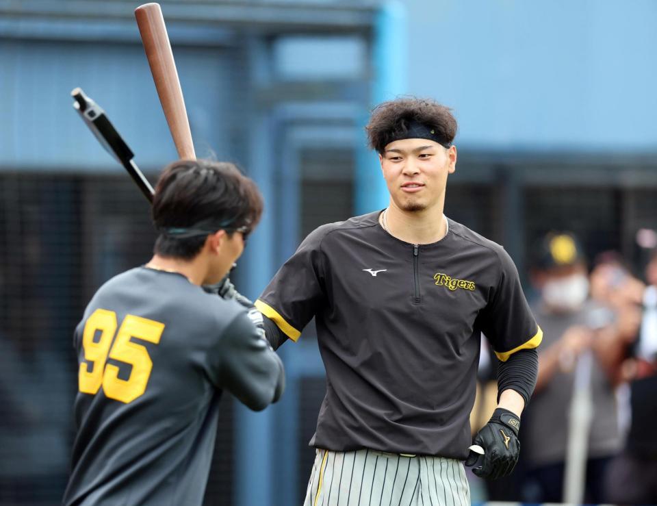 　練習中、片山（左）と談笑する佐藤輝（撮影・山口登）