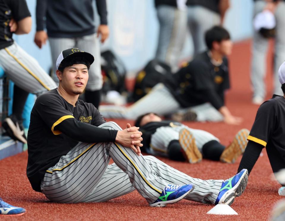 　ベンチ前でストレッチする佐藤輝（撮影・山口登）