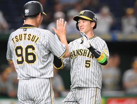 　１回、先頭打者本塁打を放ち筒井コーチ（左）に迎えられる近本（撮影・堀内翔）