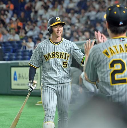 　１回、左中間スタンドへ先頭打者本塁打を放ち、ナインの出迎えを受ける近本（撮影・立川洋一郎）