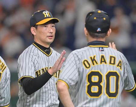 　延長１２回を抑え、岡田監督（右）とタッチを交わす岩崎（撮影・立川洋一郎）