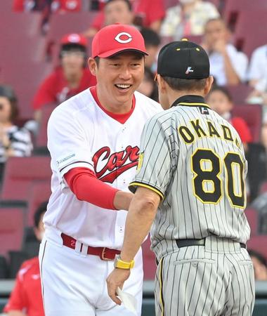 　試合前、岡田監督（右）と握手を交わす新井監督（撮影・高部洋祐）