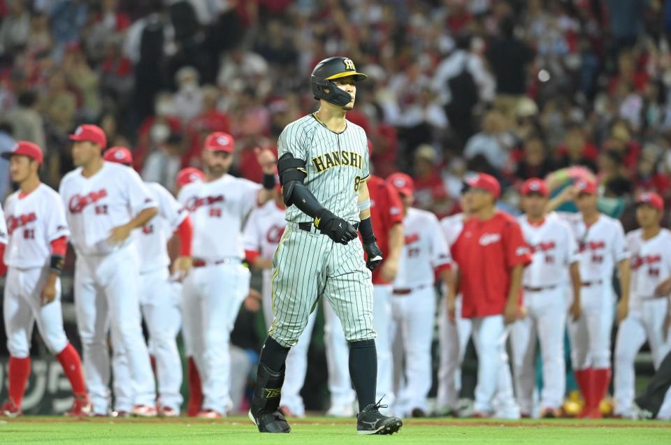 　９回、二飛に倒れ、勝利を喜ぶ広島ナインを背にベンチに戻る佐藤輝（撮影・高部洋祐）