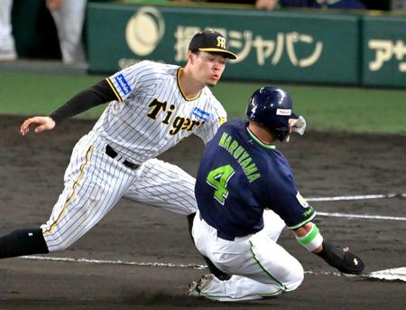 　一走丸山和（右）をタッチアウトにする佐藤輝（撮影・立川洋一郎）