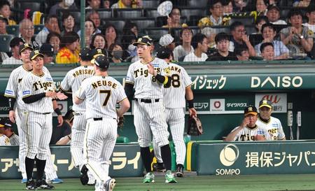 　７回表の守備を終えたナインを迎える佐藤輝（中央）。後方右端は岡田監督（撮影・中田匡峻）