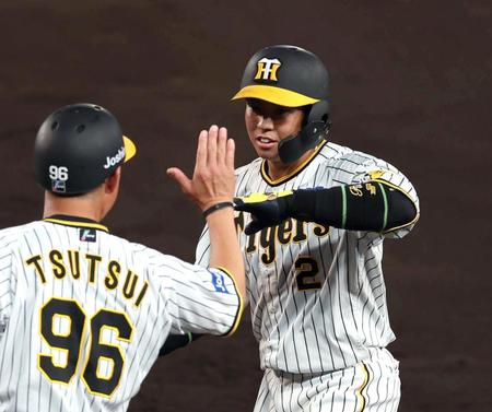 　４回、中前に勝ち越し適時打を放ち筒井コーチとタッチを交わす梅野（撮影・山口登）