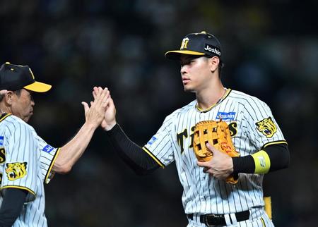 　岡田監督（左）とタッチを交わす佐藤輝（撮影・中田匡峻）