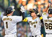 　１回、先制３ランを放った佐藤輝は二走の森下（１）とタッチを交わす（撮影・中田匡峻）