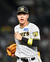 　７回の守備を終え、西純に声をかけながらベンチに戻る佐藤輝（撮影・中田匡峻）