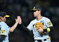 　岡田監督（左）とタッチを交わす佐藤輝（撮影・中田匡峻）