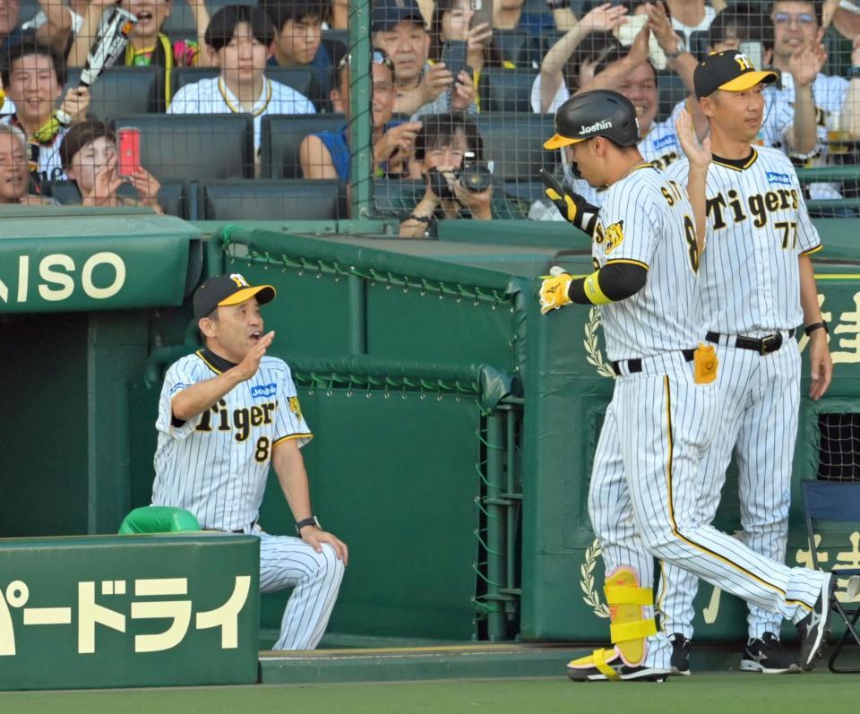 　１回、先制３ランを放った佐藤輝を迎える岡田監督（撮影・立川洋一郎）