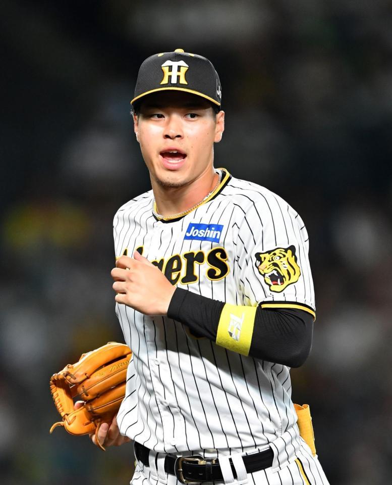 　７回の守備を終え、西純に声をかけながらベンチに戻る佐藤輝（撮影・中田匡峻）