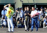 　花束を手に横田慎太郎さん（左手前）の元に歩み寄る父・真之さん（右手前）ら家族＝２０１９年９月