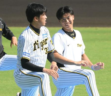 　笑顔でストレッチする湯浅（右）と才木（撮影・石井剣太郎）