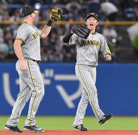 　ヤクルトに勝利し、ノイジー（左）とタッチを交わす近本（撮影・高部洋祐）