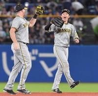 　ヤクルトに勝利し、ノイジー（左）とタッチを交わす近本（撮影・高部洋祐）