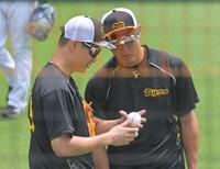 　西純（右）に変化球の握りをアドバイスする大竹（撮影・立川洋一郎）