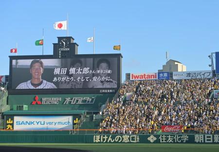 　横田慎太郎さんの追悼ビデオが流され、黙とうを捧げるファン（撮影・立川洋一郎）