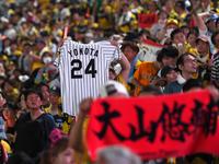 　横田さんのユニホームを手に勝利を喜ぶ阪神ファン（撮影・飯室逸平）