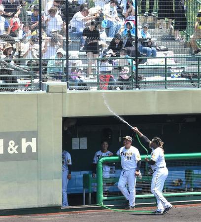 　試合前、ホースから出る水を観客席に向けてぶっ放すミエセス（右下）＝撮影・北村雅宏