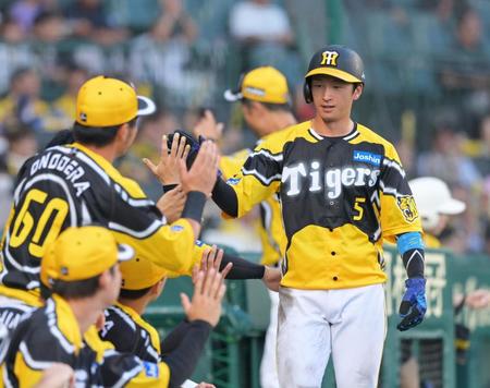 　１回、森下の先制適時打で生還しナインとタッチを交わす近本（撮影・立川洋一郎）