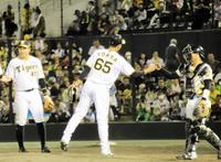 　九回に登板し試合を締めて中川とグータッチを交わす湯浅