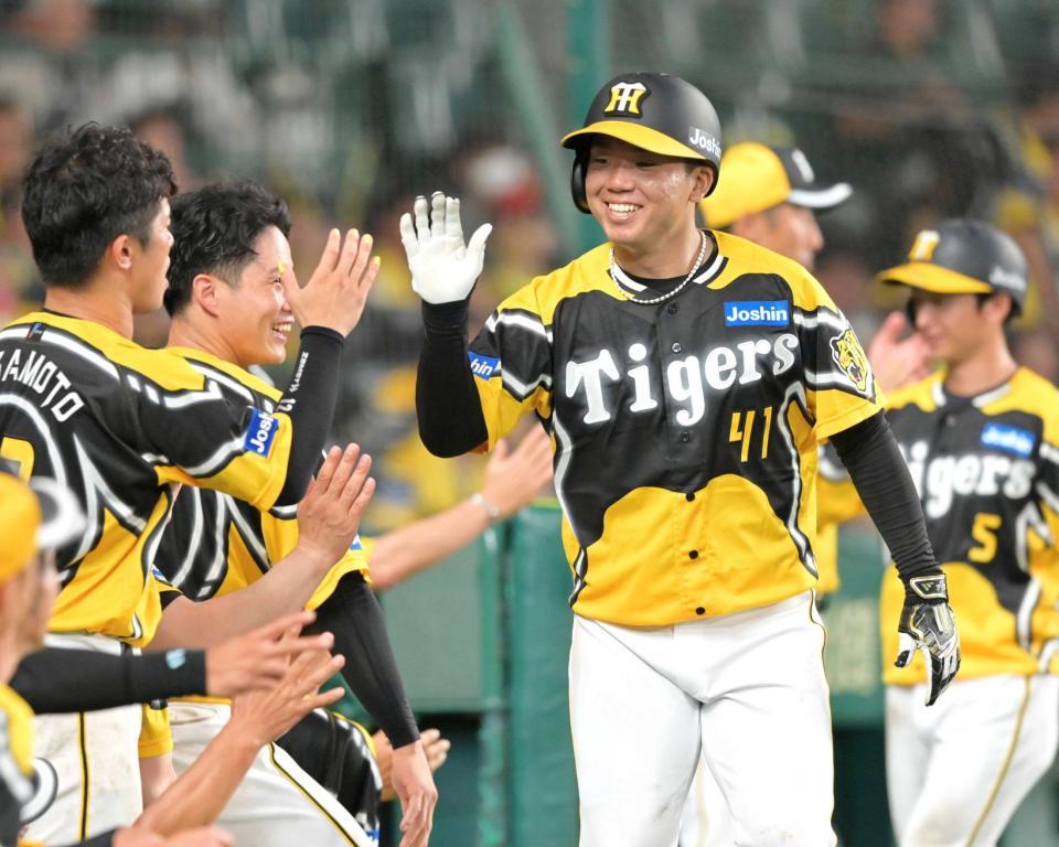 　６回、森下の２点適時打で生還し出迎えるナインと笑顔でタッチを交わす村上