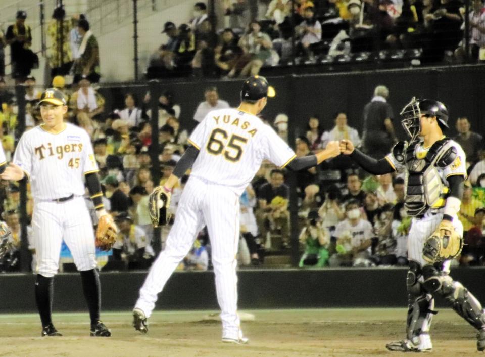 　九回に登板し試合を締めて中川とグータッチを交わす湯浅
