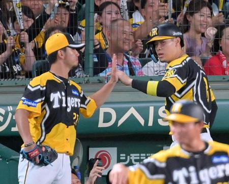 　６回、ノイジーの適時内野安打で生還し伊藤将（左）とタッチを交わす佐藤輝（撮影・立川洋一郎）