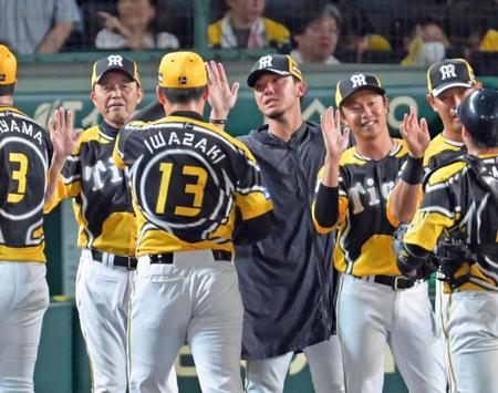 　伊藤将（中央）らと勝利のタッチを交わす岡田監督（左端）＝撮影・立川洋一郎