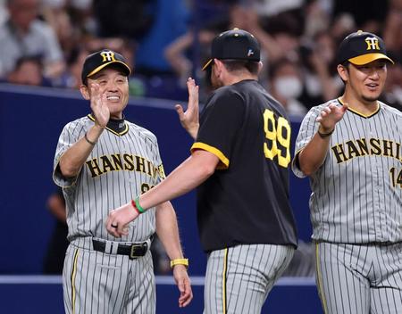 　来日初勝利を挙げたビーズリーと笑顔でタッチする岡田監督（左）＝撮影・山口登