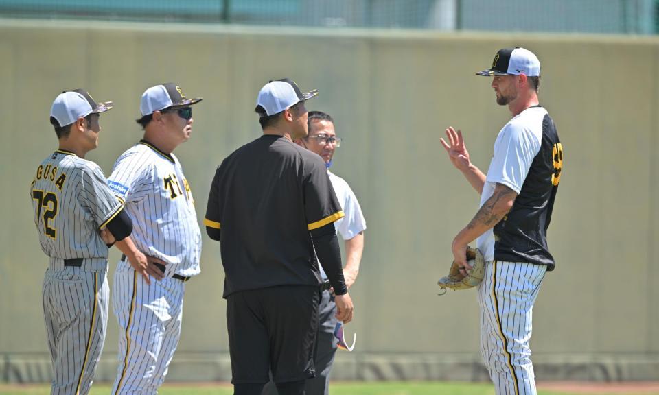 　キャッチボールを終え、福原２軍投手コーチ（左から２人目）らと話をするブルワー（右端）＝撮影・中田匡峻