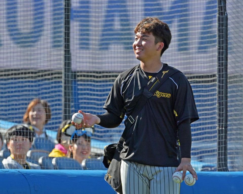 　投手陣のサイン入りボールを子どもたちにプレゼントする村上（撮影・立川洋一郎）