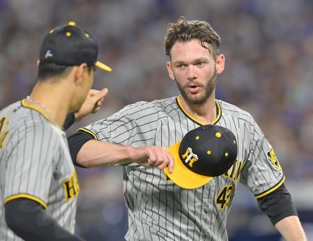 　８回裏を無失点に抑え、佐藤輝（左）とタッチを交わすＫ・ケラー（撮影・立川洋一郎）