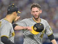 　８回裏を無失点に抑え、佐藤輝（左）とタッチを交わすＫ・ケラー（撮影・立川洋一郎）