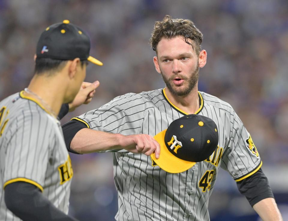 　８回裏を無失点に抑え、佐藤輝（左）とタッチを交わすＫ・ケラー（撮影・立川洋一郎）