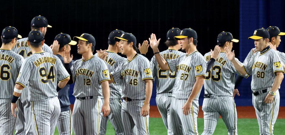 　ＤｅＮＡに３連勝し、笑顔でナインとタッチを交わす島本（４６）ら阪神ナイン。右端は岡田監督