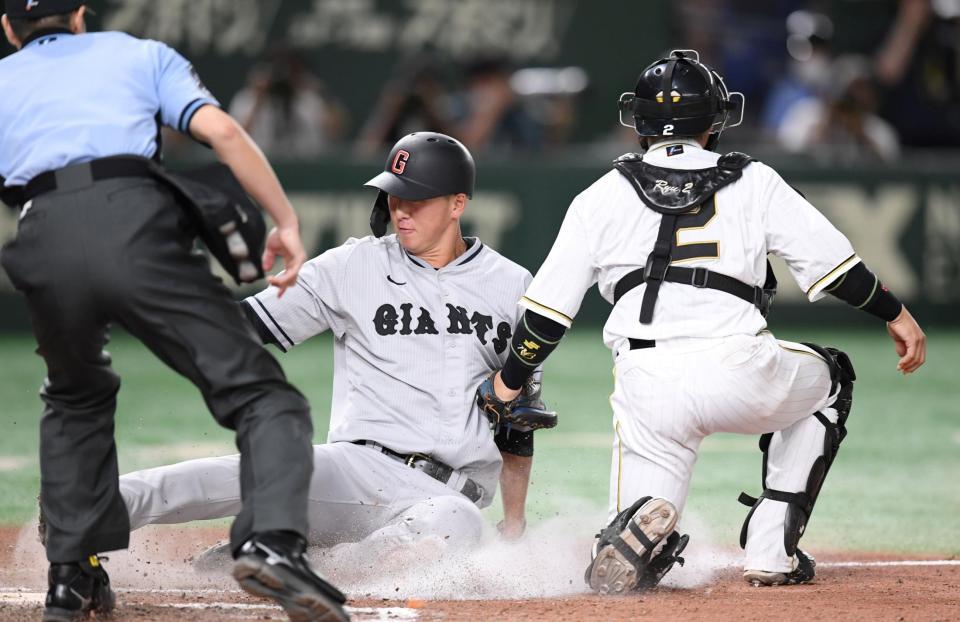 　８回、岡本和の安打で本塁に滑り込む秋広。捕手は梅野（撮影・棚橋慶太）