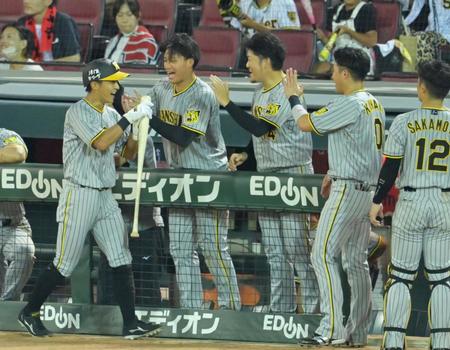 　９回、代打・原口の適時打で生還しナインの出迎えに笑顔を見せる熊谷（左端）＝撮影・立川洋一郎